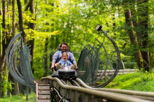 Father and daughter have fun on the Wisp Resort Mountain Coaster located at the Mountain Park.